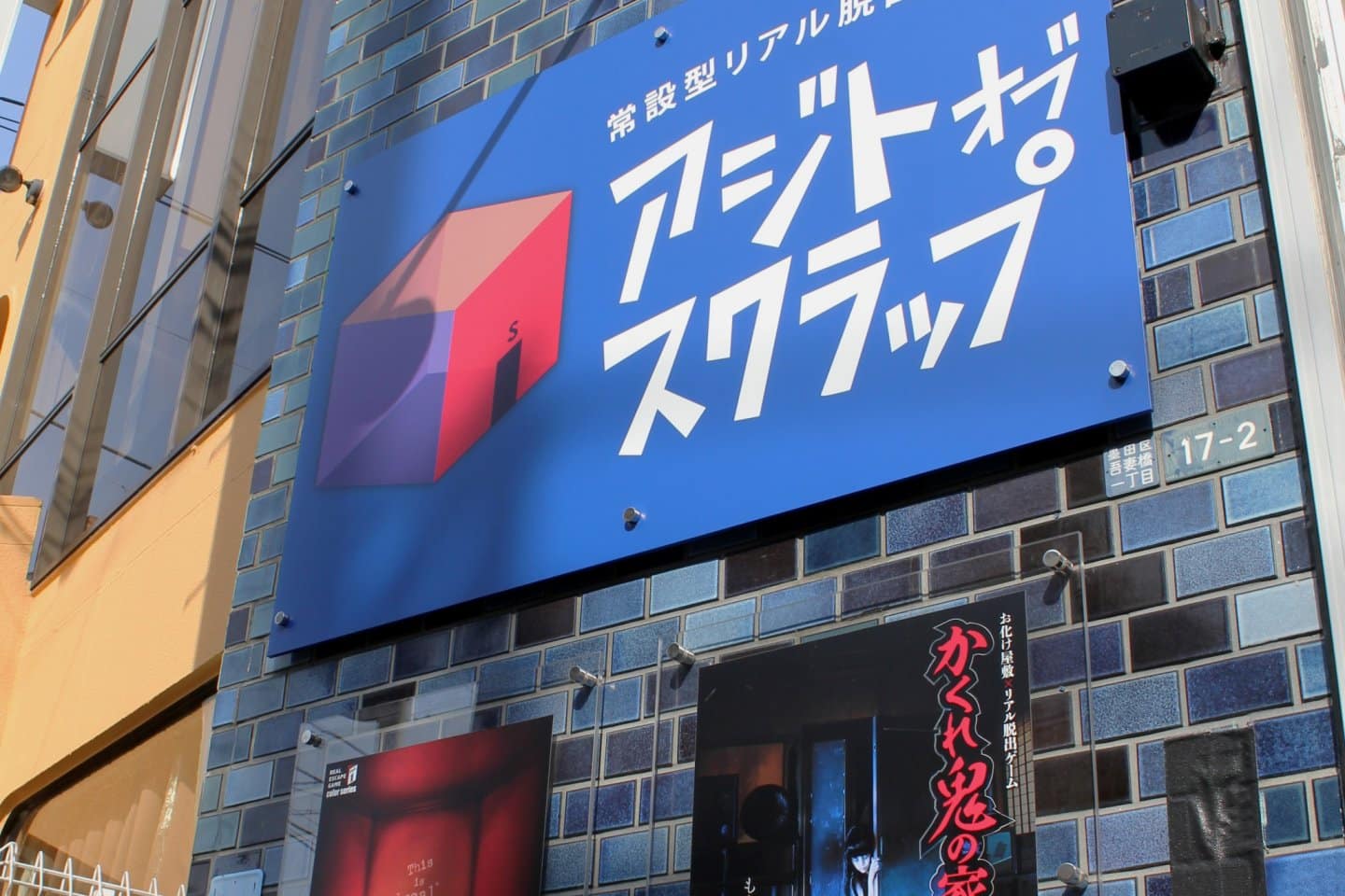 تابلویی با متن ژاپنی و انگلیسی که در خارج از ساختمان با فونت و طرح سبک یکپارچهسازی با سیستمعامل، با آرم نمادین ویندوز، نشان‌دهنده یک تجارت مرتبط با فناوری یا رایانه است.